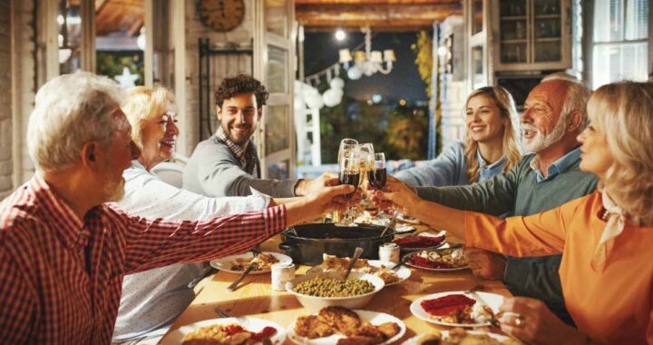 A close-knit family gathering around a rustic farm table, sharing a Thanksgiving meal and raising their wine glasses in a heartwarming toast.