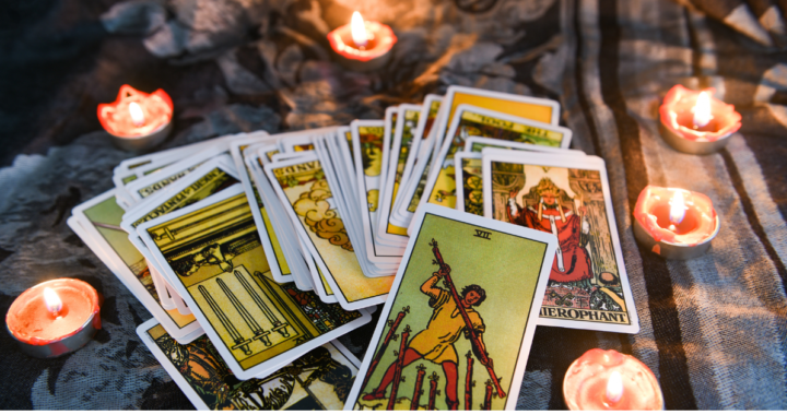 Tarot cards surrounded by light candles representing spiritual self-discovery.